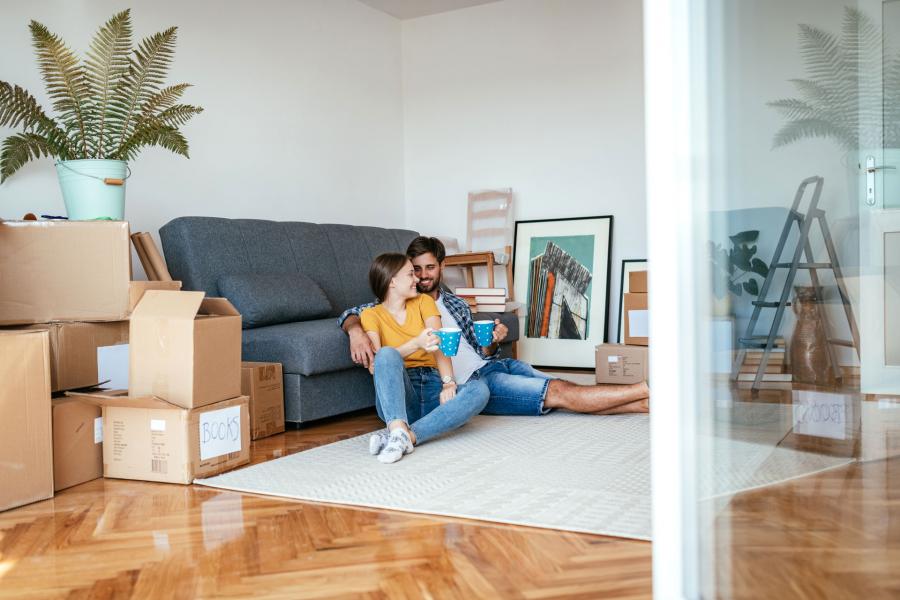 A man and woman sitting and smiling in their house