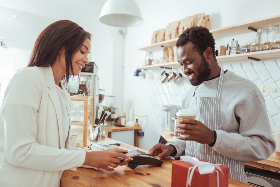 Woman paying for coffee using her phone